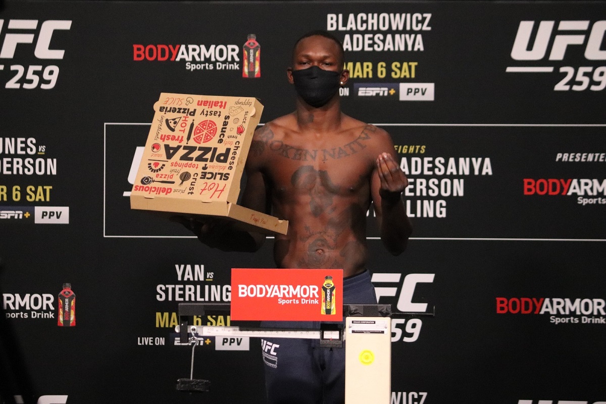 Israel Adesanya rouba a cena em pesagem do UFC com caixa de pizza na balança