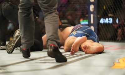 Chris Weidman deitado no octógono após ter fraturado a perna em luta contra Uriah Hall no UFC 261.