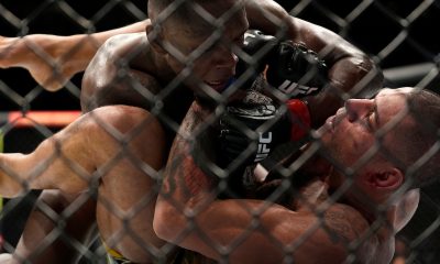 Israel Adesanya trabalha no chão por cima de Alex Poatan na disputa pelo título peso-médio no UFC 281.