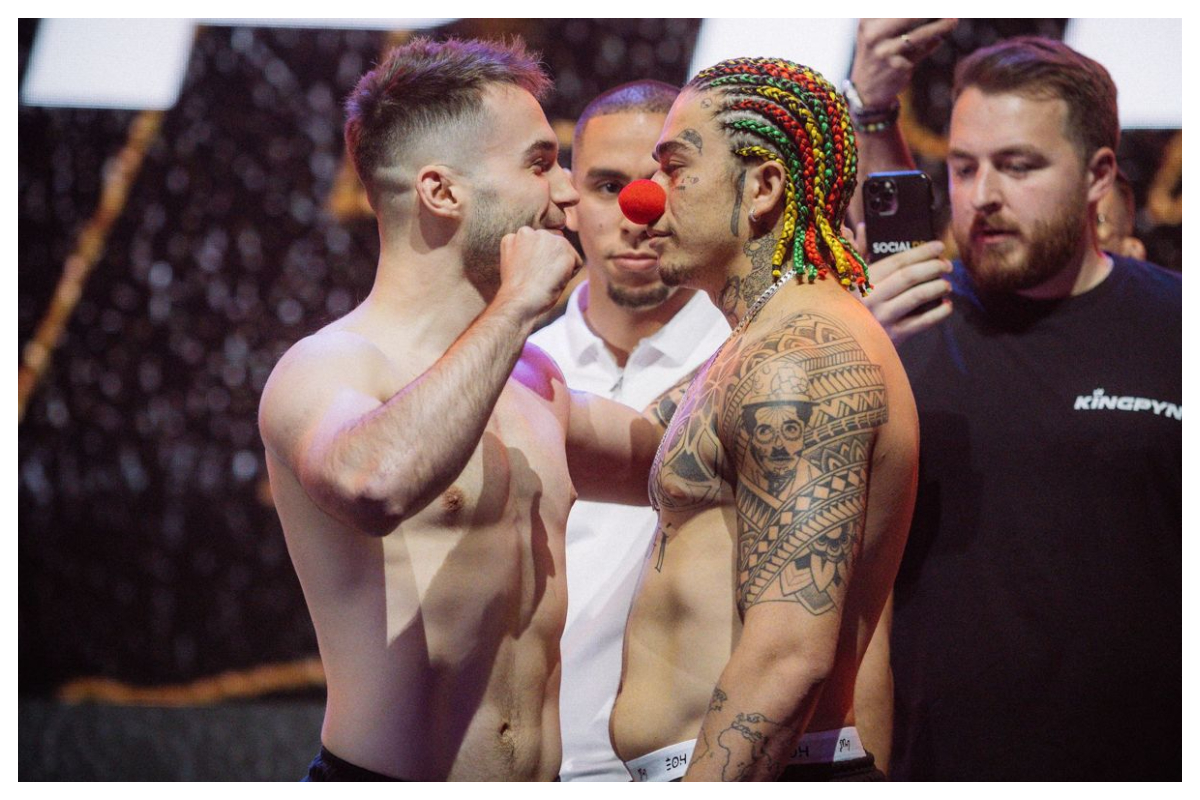 Com tranças coloridas e um nariz de palhaço, comediante brasileiro debocha das provocações do rival