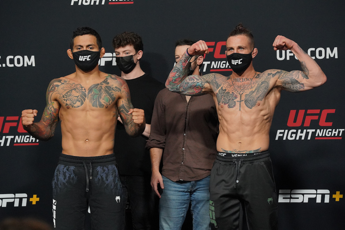 Diego Ferreira e Gregor Gillespie posam para fotos de máscara após protagonizarem encarada no UFC.