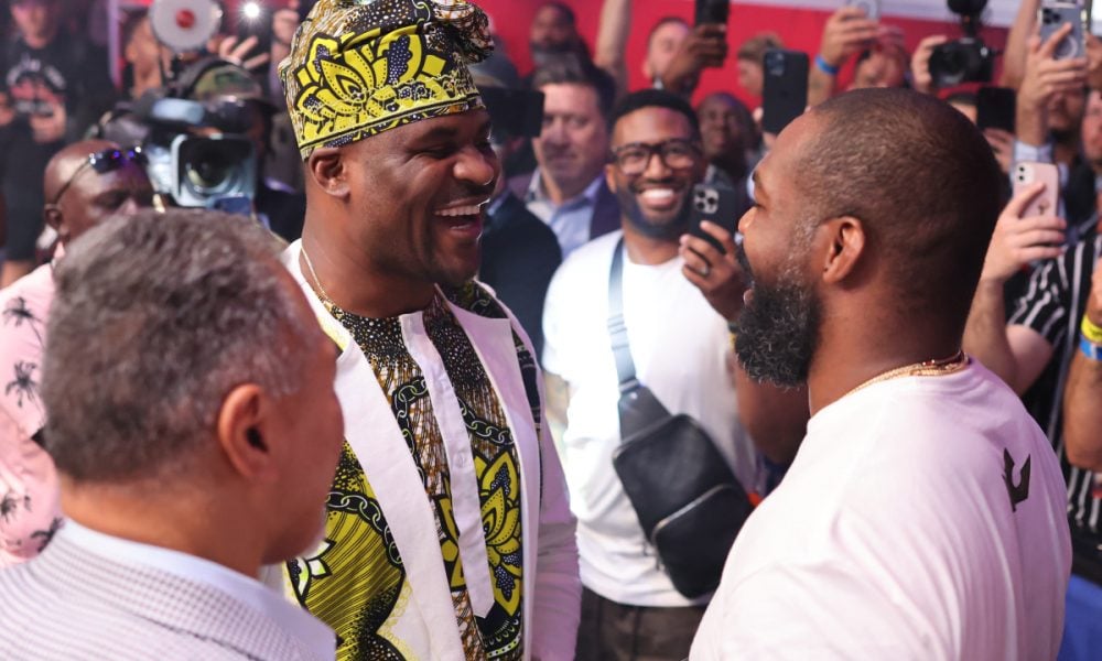 Francis Ngannou e Jon Jones se encaram de forma sorridente ao final da PFL Atlanta