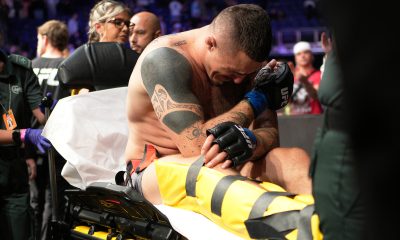 Tom Aspinall deixa a O2 Arena de maca após lesionar o joelho na luta principal do UFC Londres, contra Curtis Blaydes.