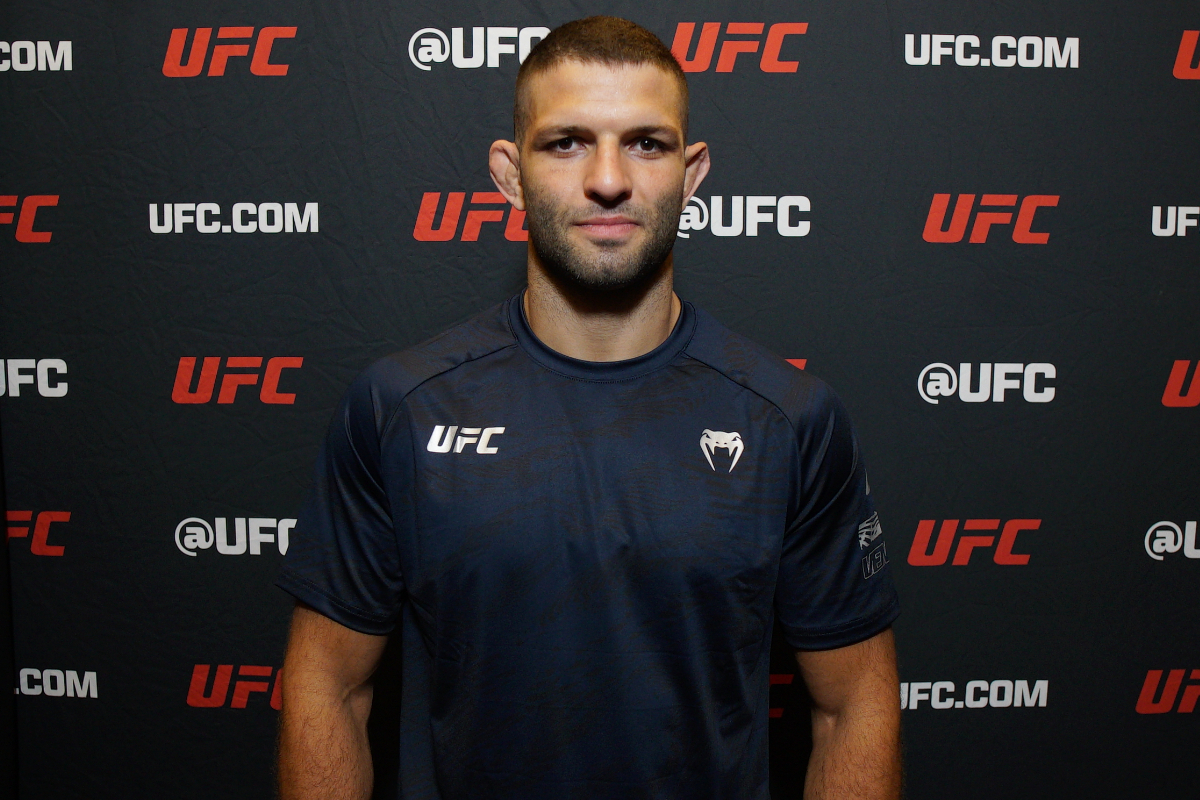 De camisa azul, Thiago Moisés posa para foto no media day do UFC Vegas 106