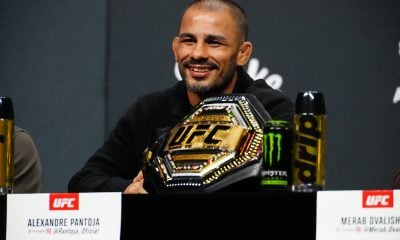 Alexandre Pantoja sorri ao lado do cinturão na coletiva do UFC 323