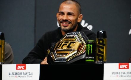 Alexandre Pantoja sorri ao lado do cinturão na coletiva do UFC 323